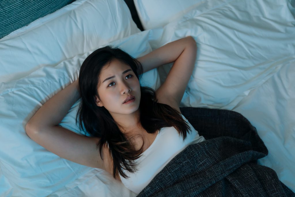 woman lying in bed late at night trying to sleep