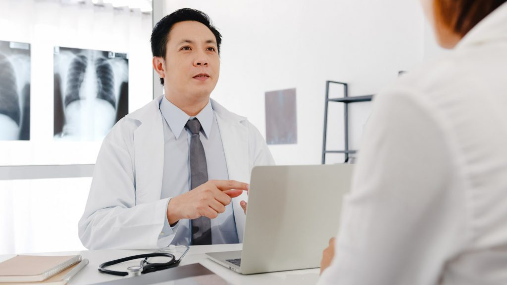 serious-asia-male-doctor-white-medical-uniform-using-computer-laptop-is-delivering-great-news-talk-discuss-results